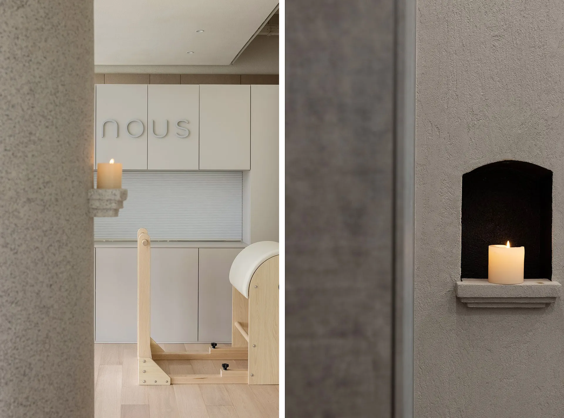 A minimalist office space with light wooden furniture and plaster walls, featuring a candle on a ledge.