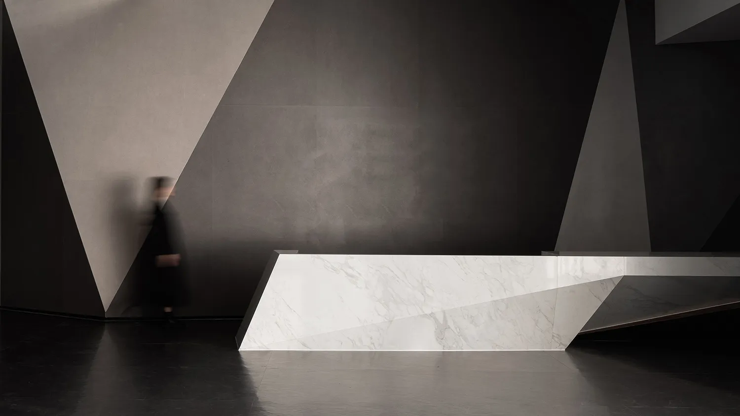 A minimalist interior featuring a marble counter and concrete walls