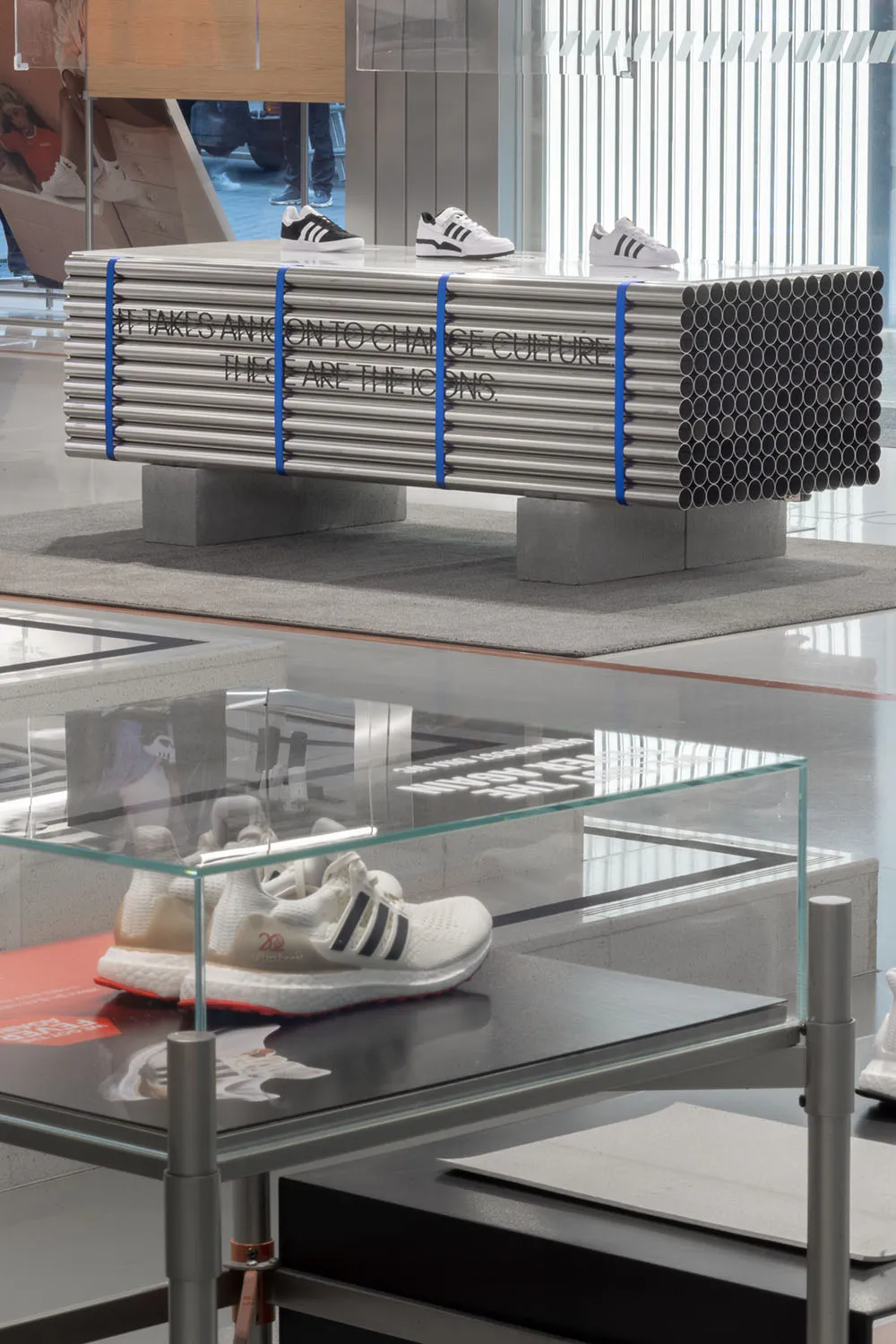 Retractable display case showcasing shoes in metallic pipes