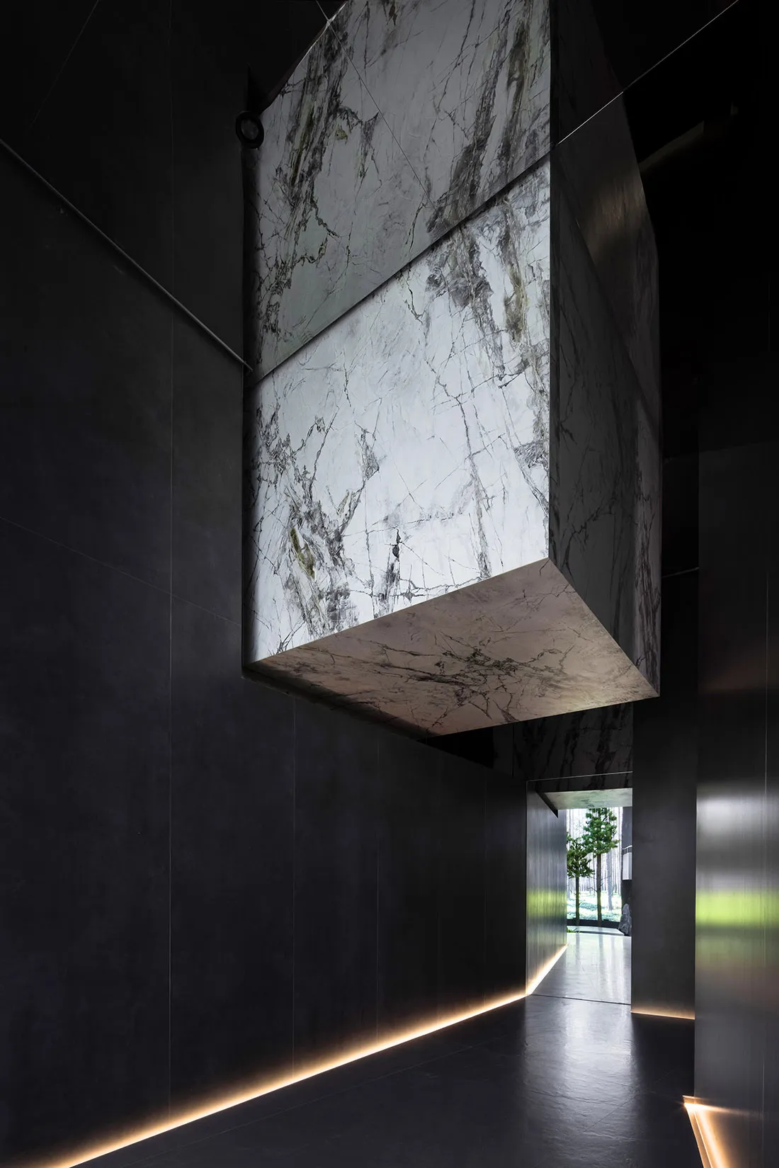 Modern minimalist interior design featuring marble elements and dark walls.