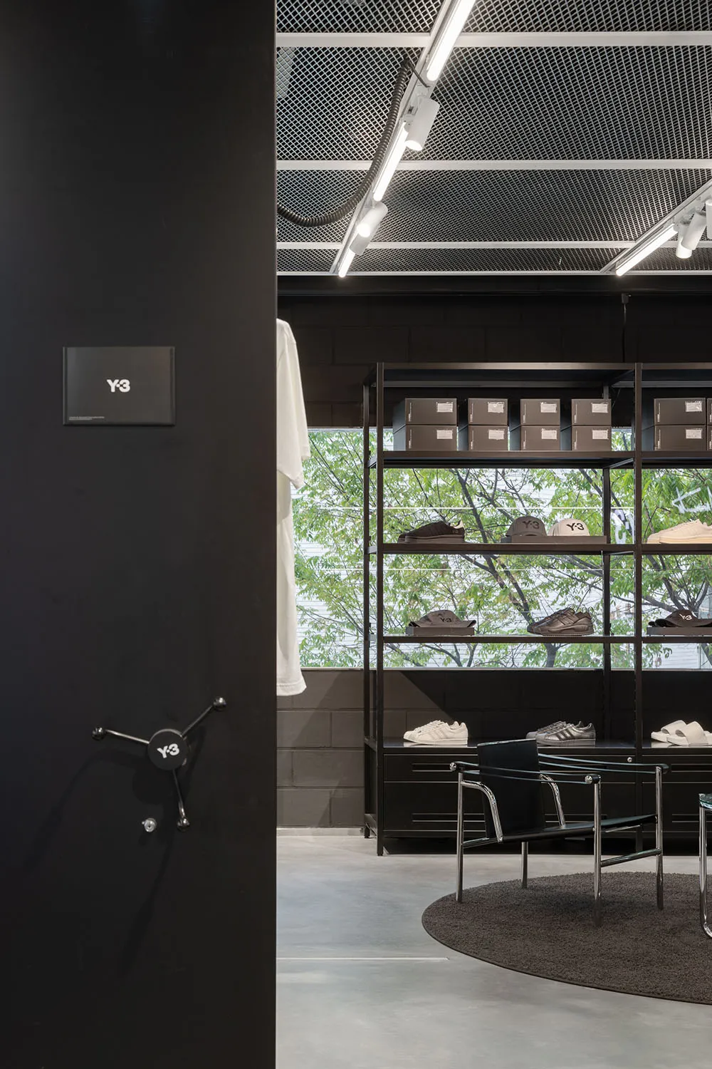 Retail space featuring minimalist design, black metal shelves, and concrete flooring.