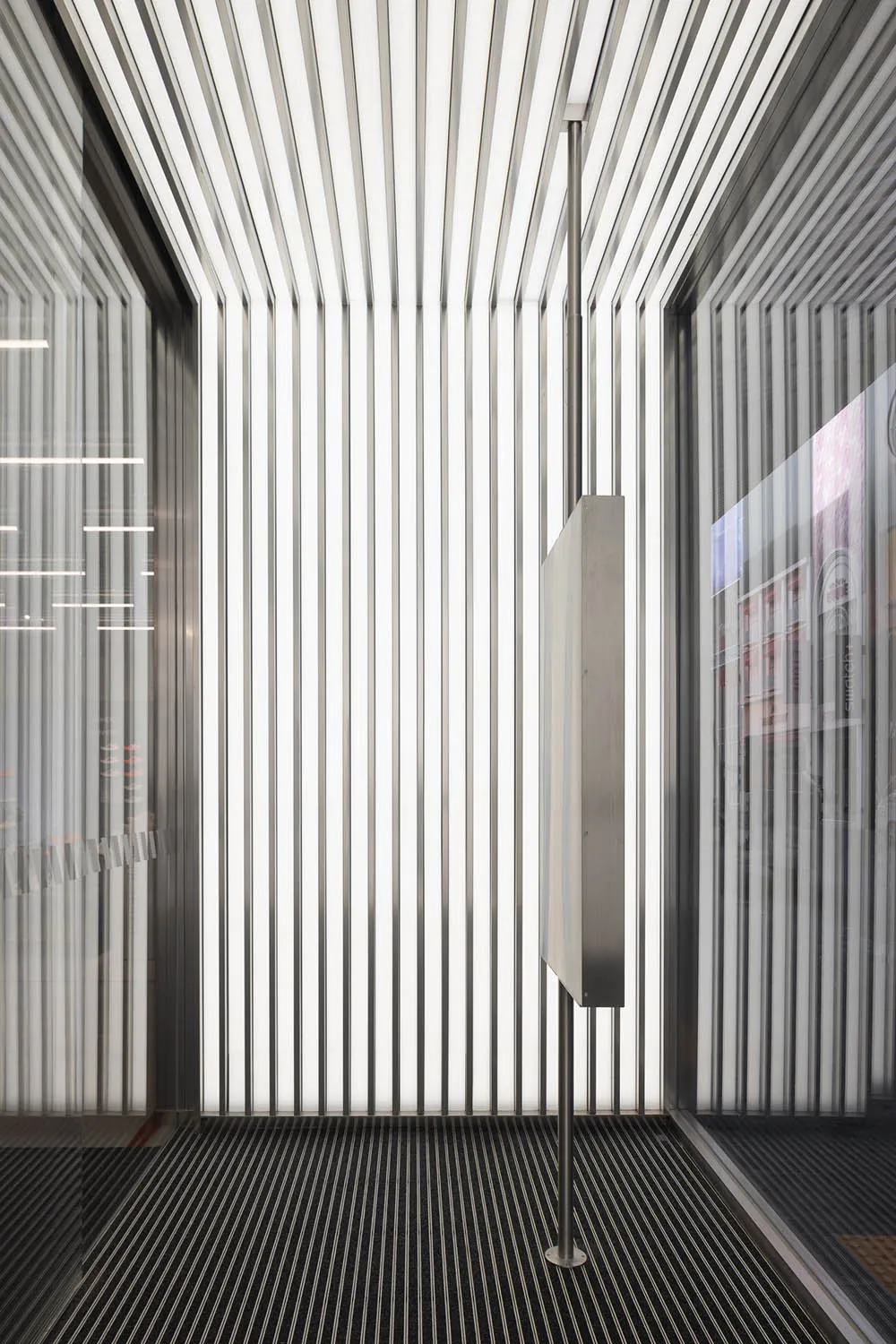 A modern interior space featuring metallic columns and vertical lines.