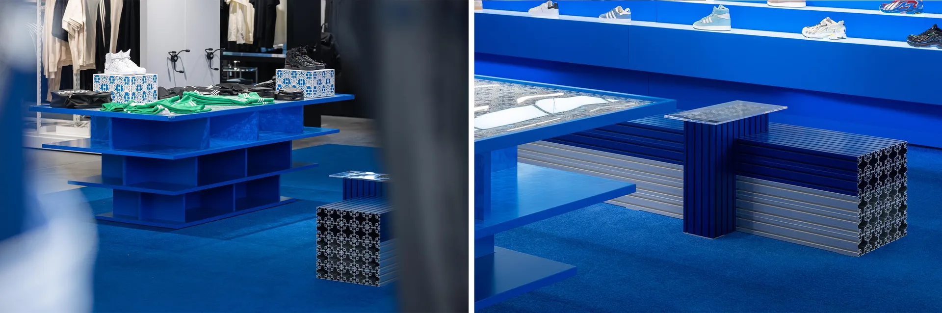 A modern retail display featuring blue metal tables, glass shelves, and fabric items for sale in a store.