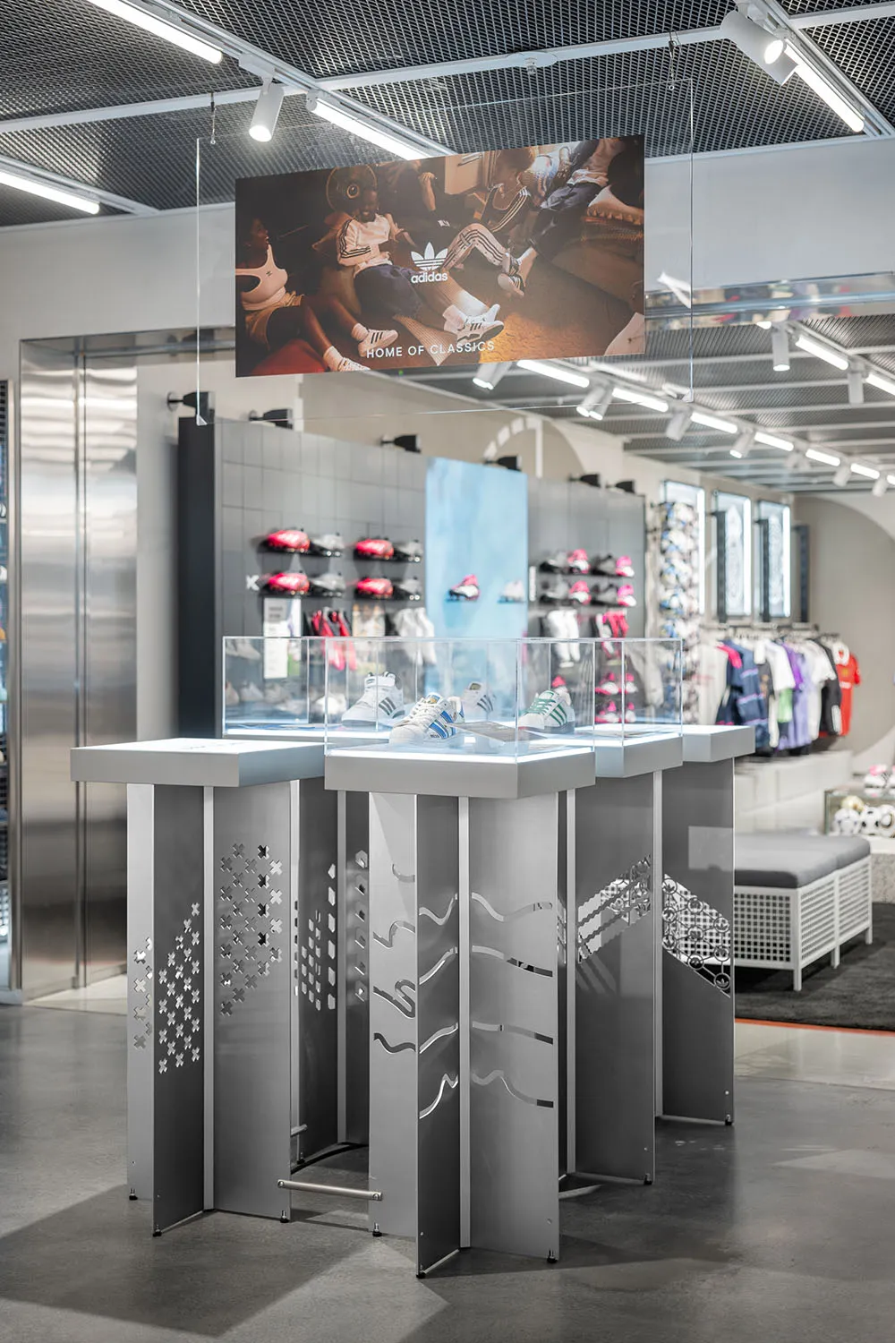 Shoe display in a retail store with metal and glass structures.