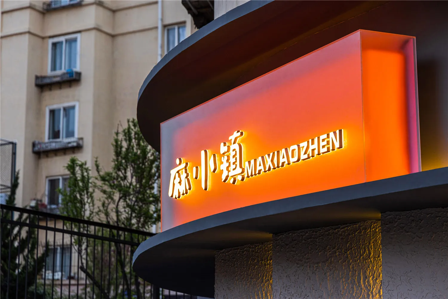 Modern, illuminated restaurant signage with Chinese characters and English text.