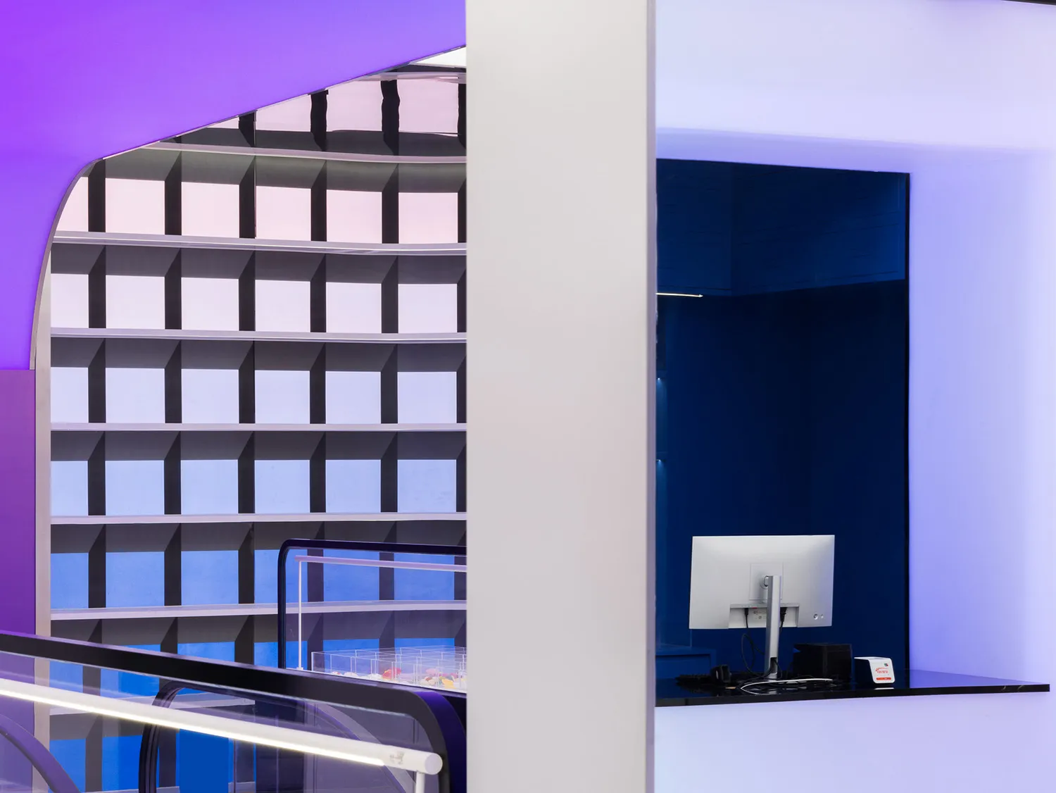 A modern office space with a glass counter and colorful cubes on the wall.
