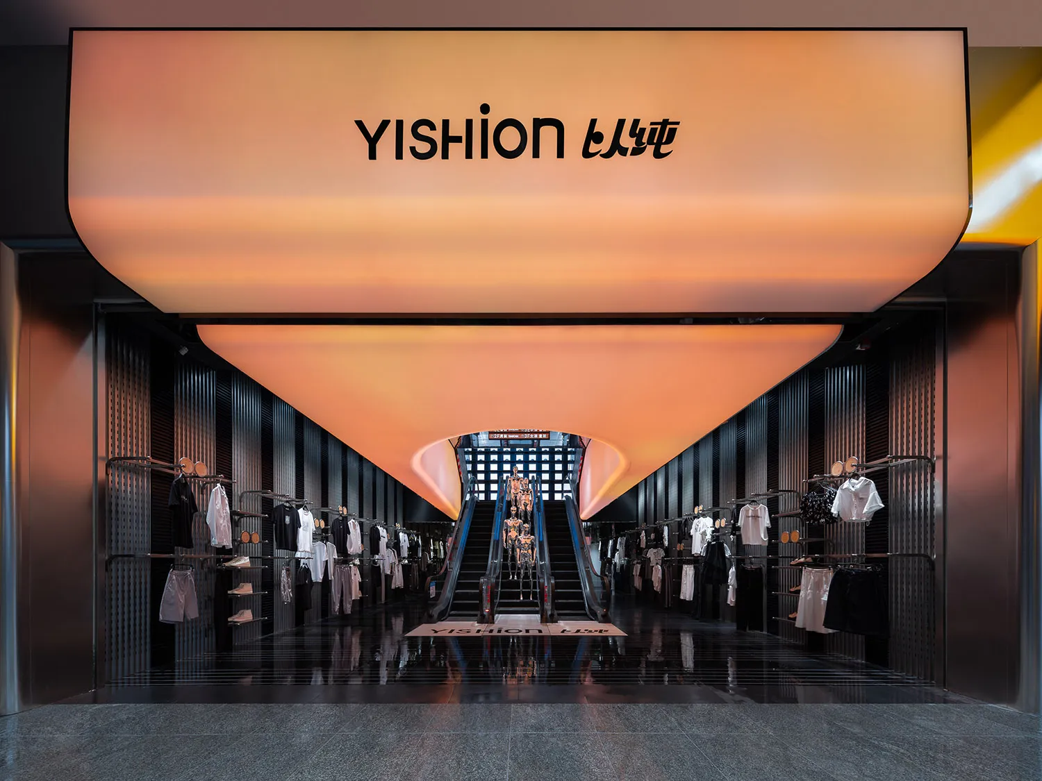 現代零售空間內的 Yishion 服飾店,設有玻璃牆、金屬欄杆與混凝土地板。