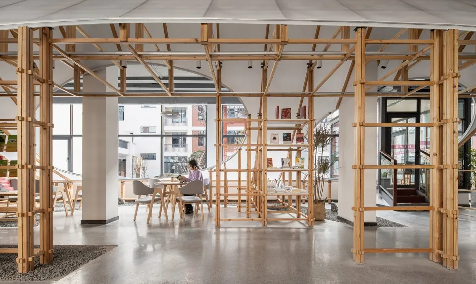 A modern cafe interior with wooden architectural frameworks and large windows allowing natural light.