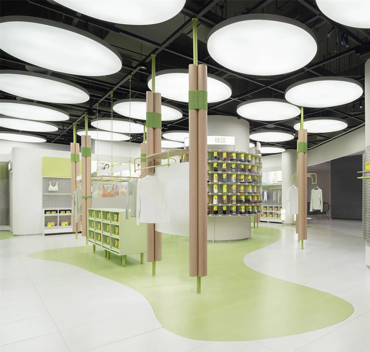 A modern retail space featuring wooden columns, green walls, and concrete flooring.