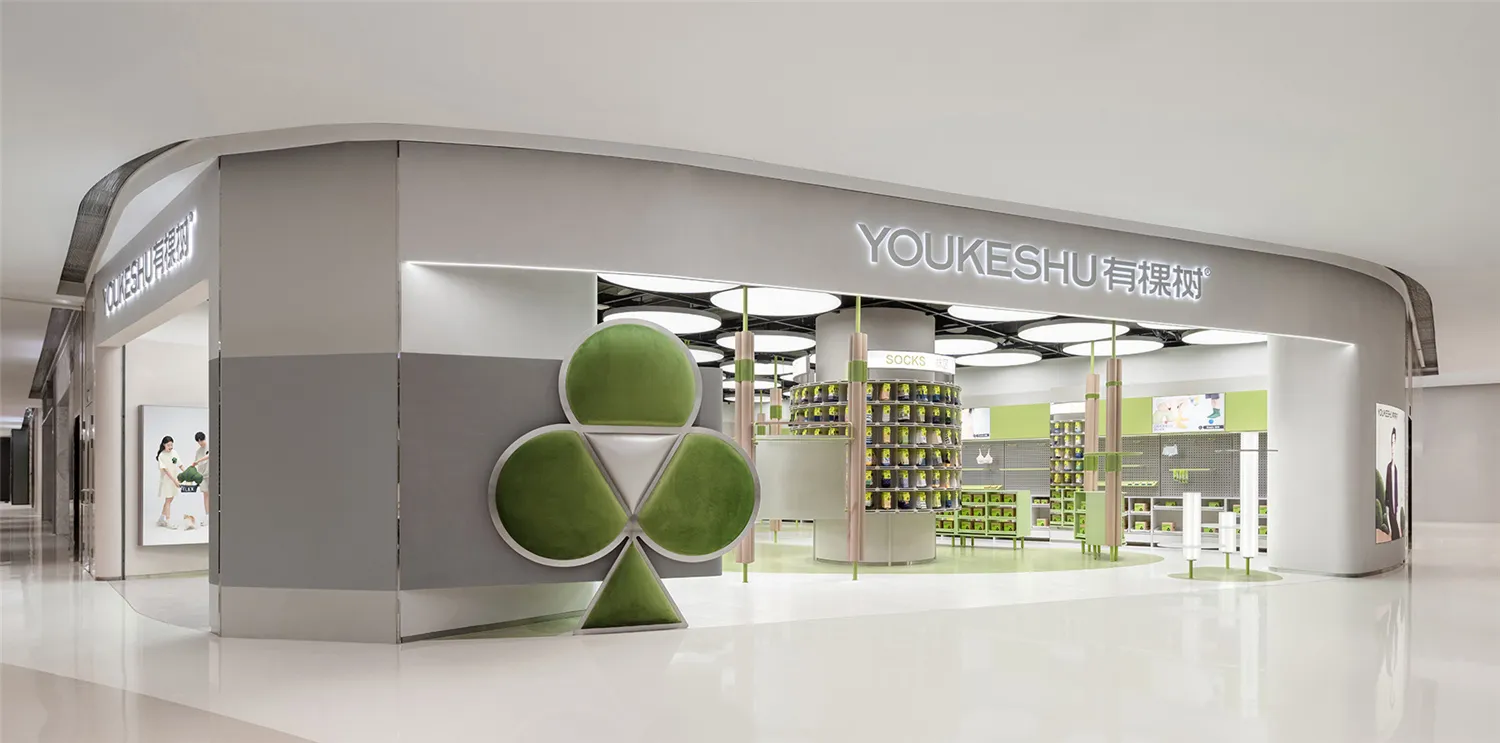 A modern retail storefront with green leaves and green materials