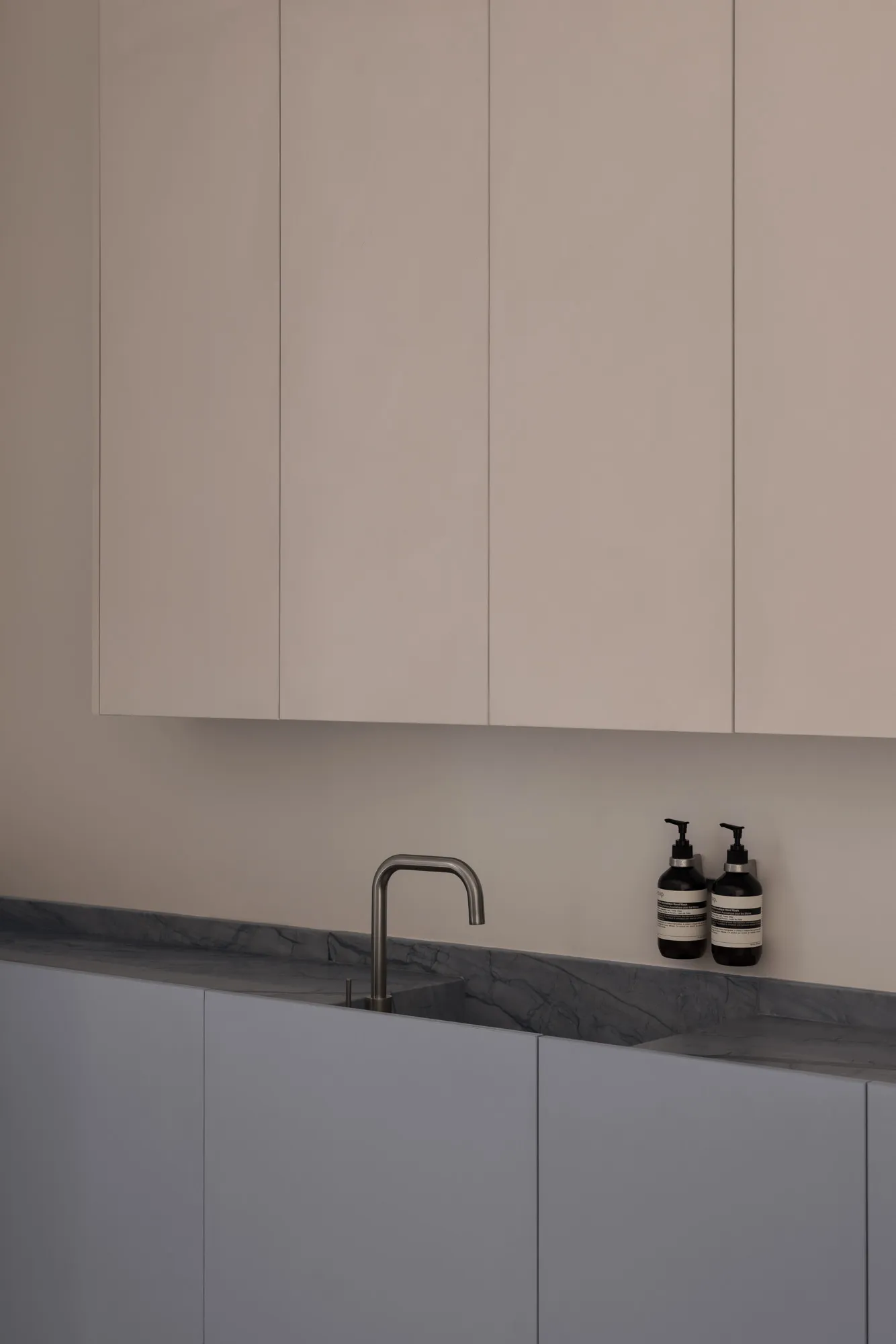Modern kitchen with minimalist design featuring concrete countertops and cabinets.