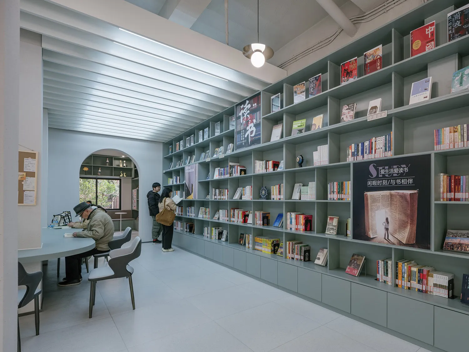 A modern library interior with concrete walls and metal shelves.