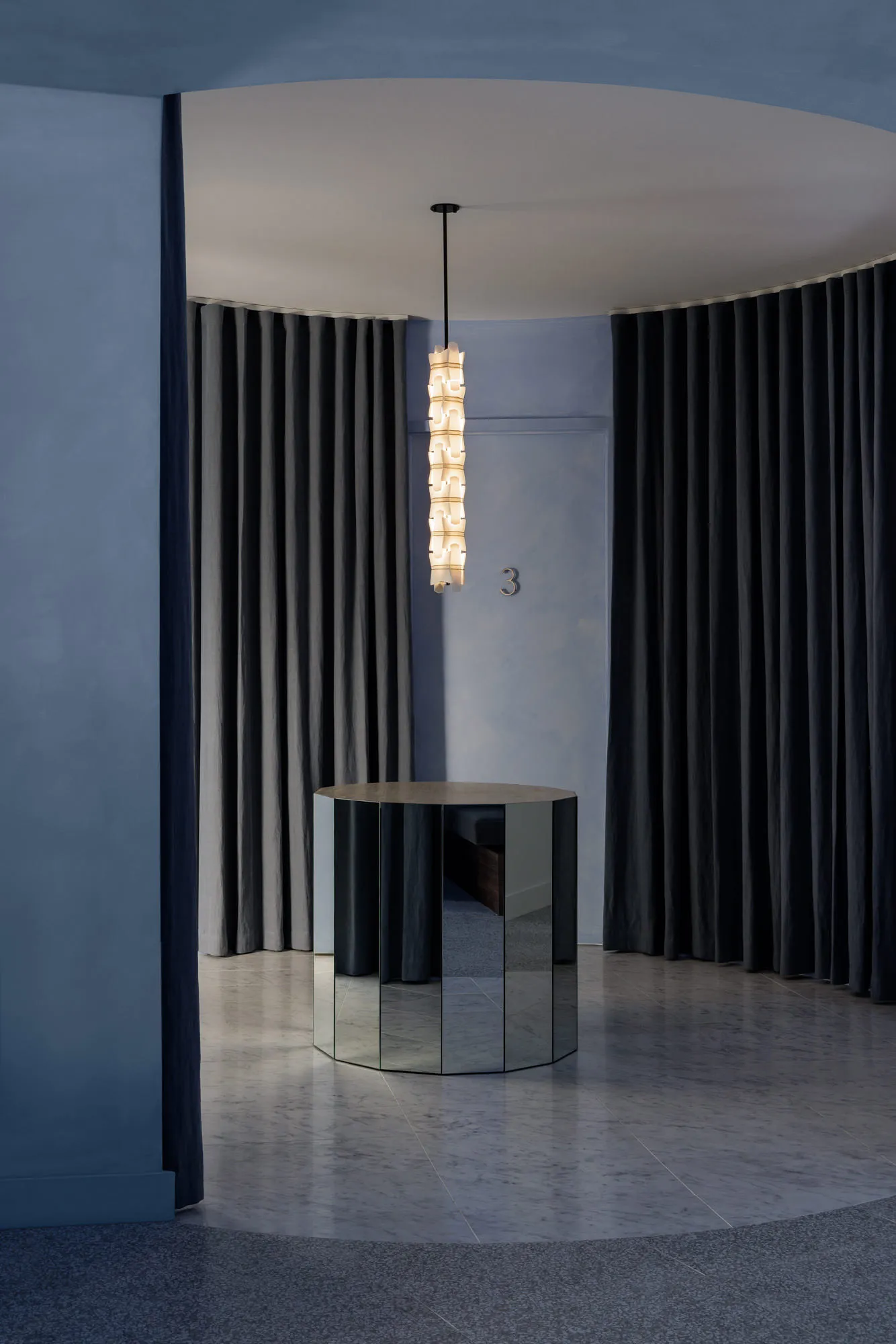 A minimalist lobby featuring a black mirrored panel with modern design elements.