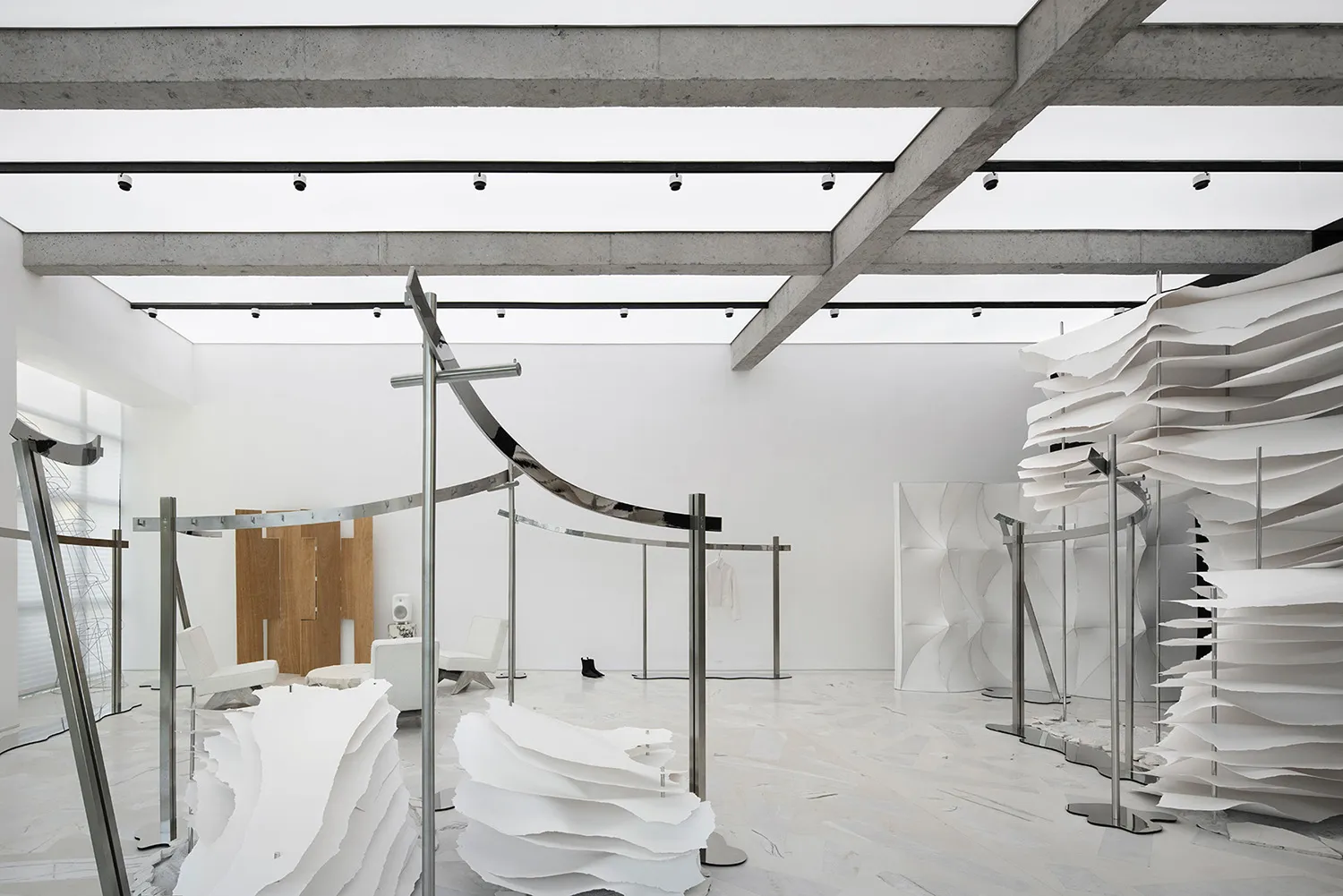 Minimalist exhibition space featuring paper and metal installations.