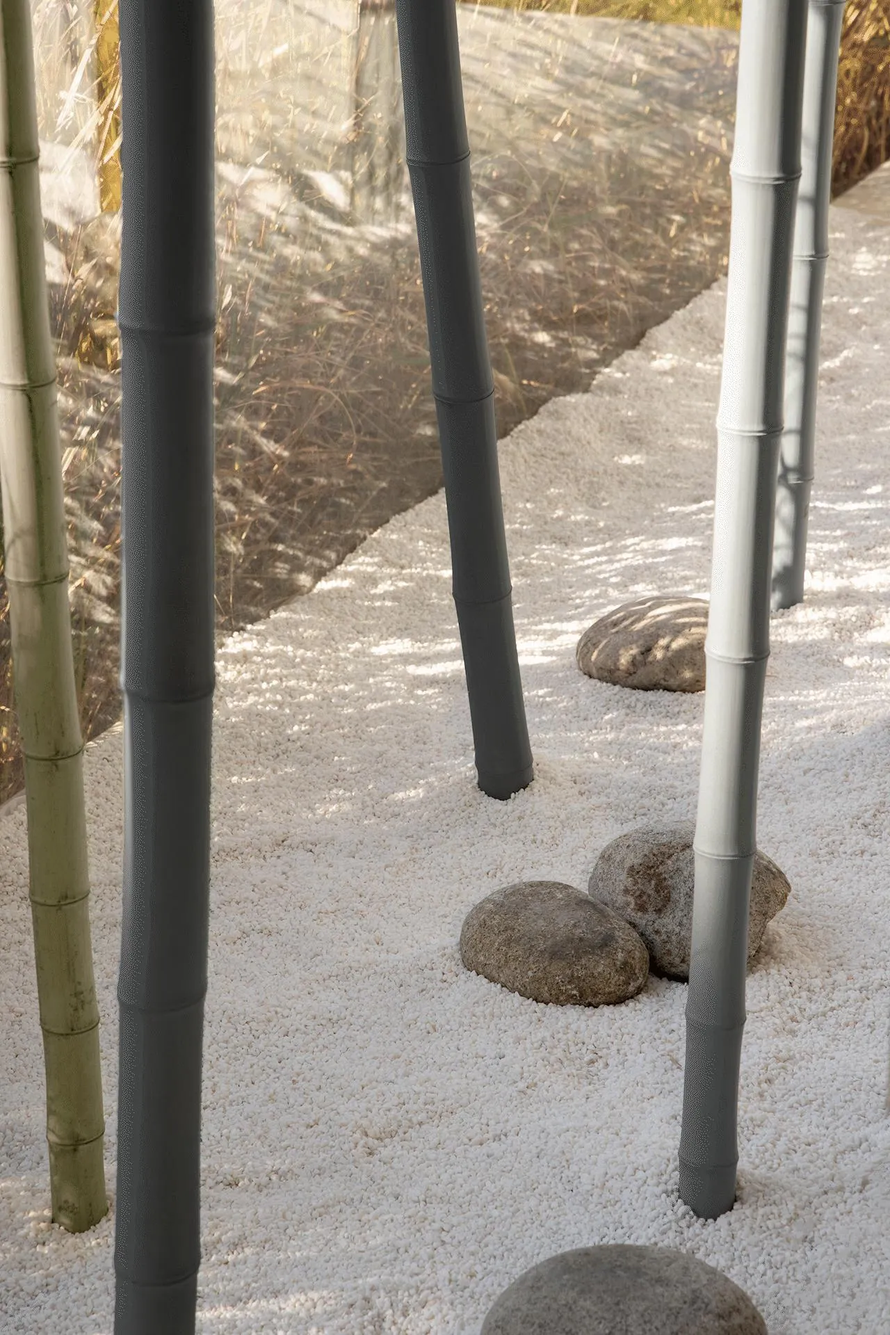A minimalist bamboo walkway lined with white pebbles, creating a serene and tranquil outdoor space.