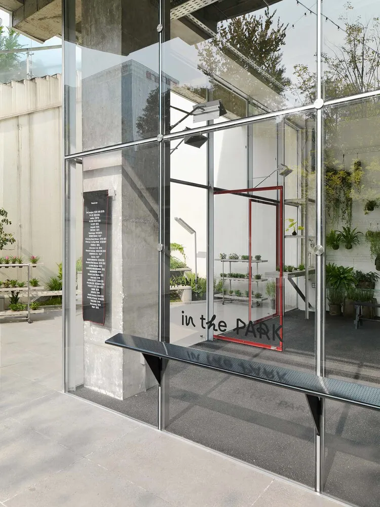 A modern glass storefront with a sign that reads 'in the PARK'.