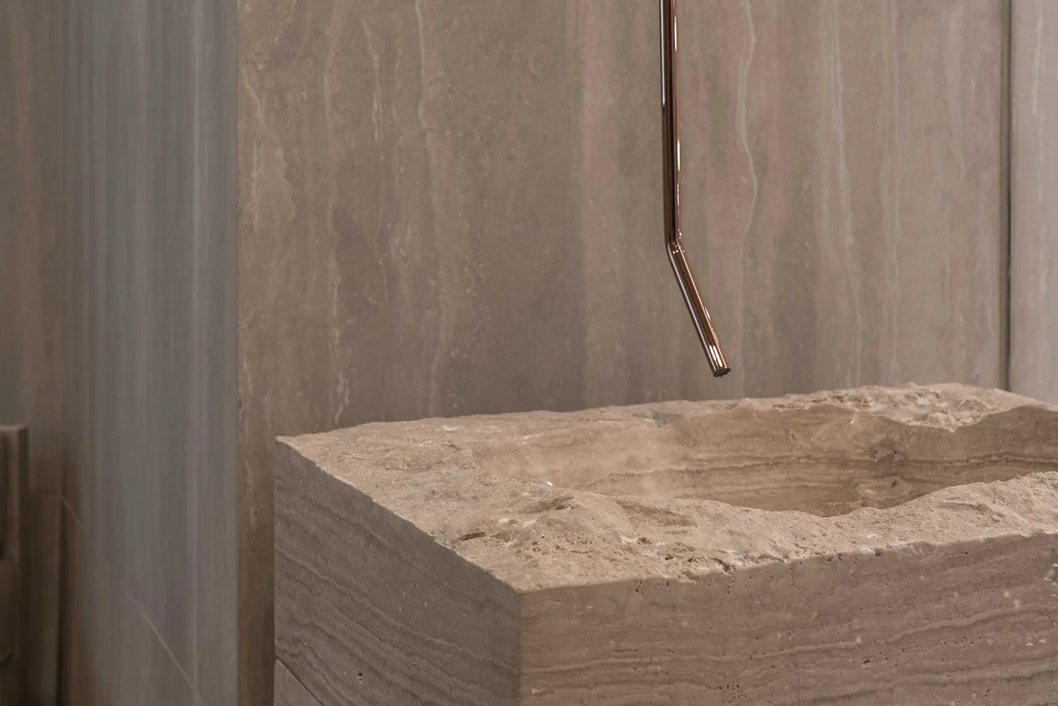 A modern interior with a stone sink, showcasing sleek and minimalist features.