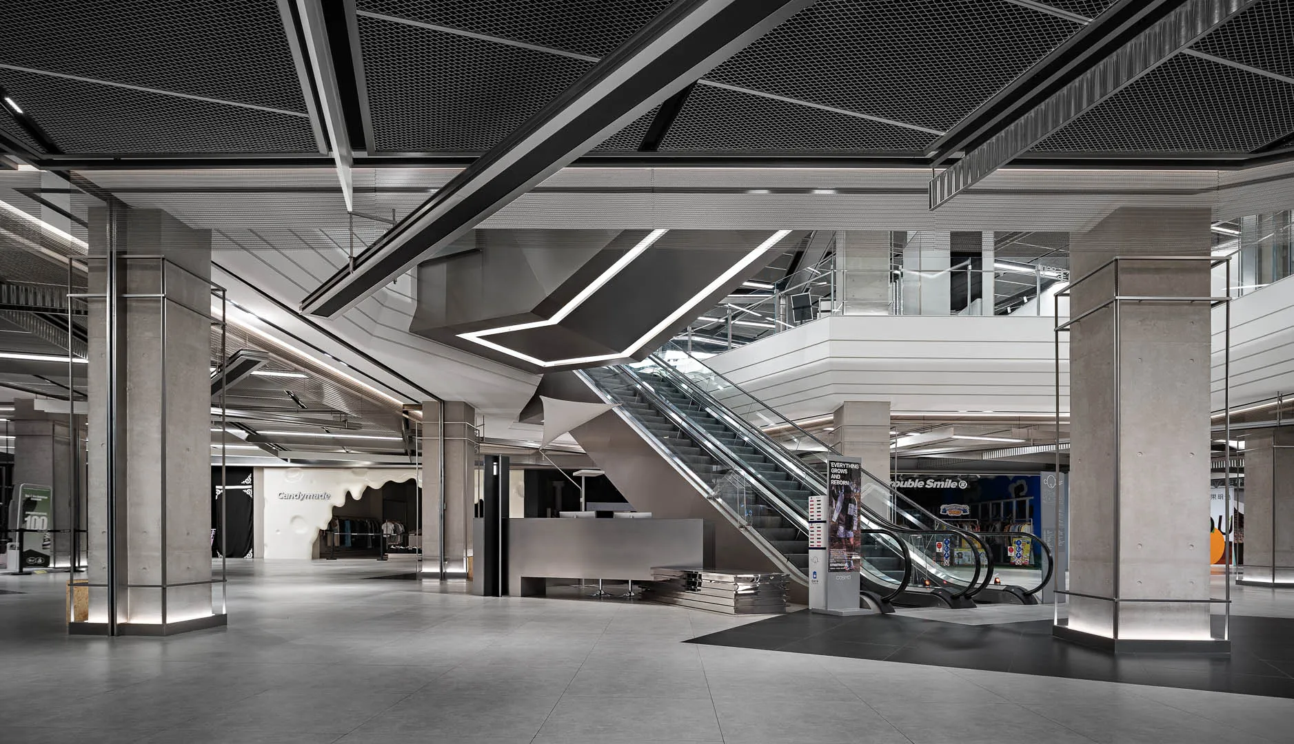 Lobby area in a modern shopping mall with concrete, glass, and steel materials.
