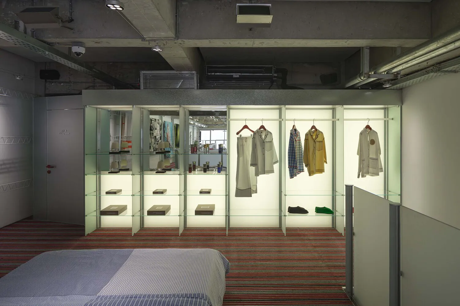 A retail showroom featuring glass shelves and clothing racks.
