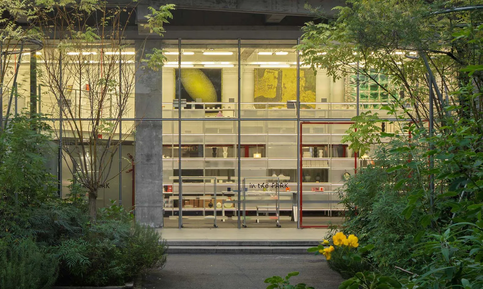Modern minimalist exhibition space with glass walls displaying artwork.