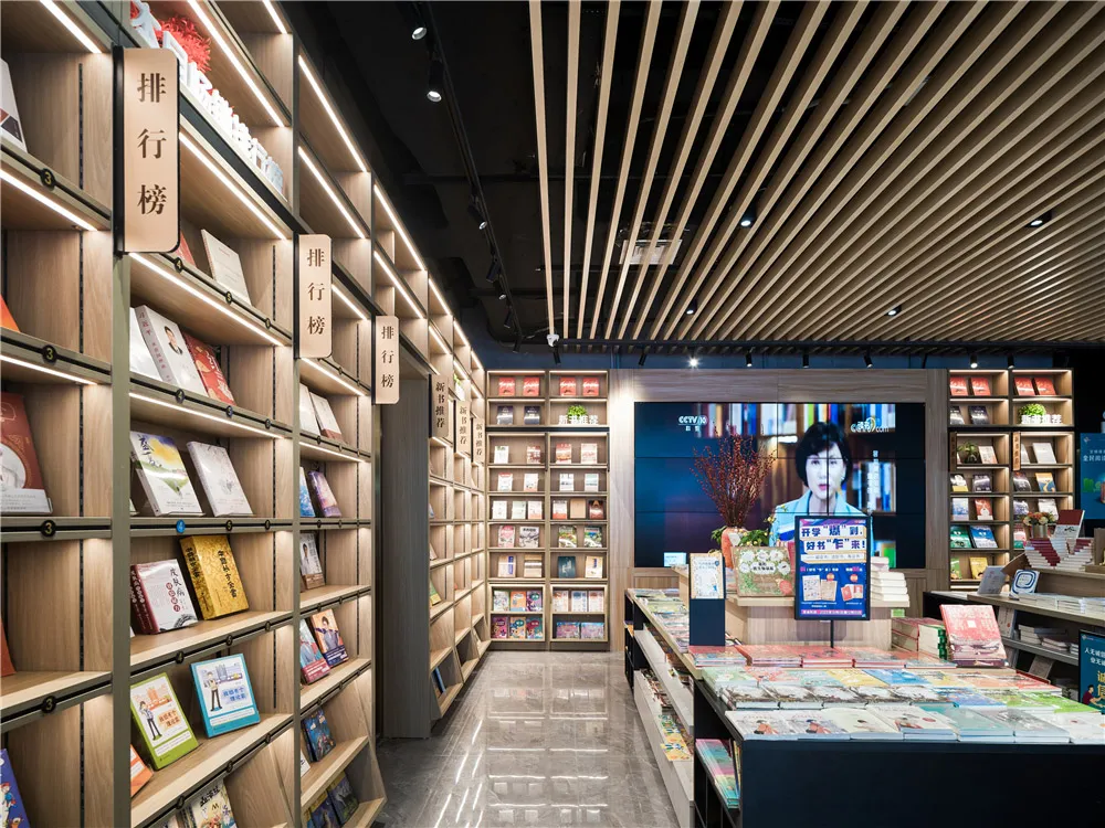 A modern bookstore with shelves filled with books, illuminated by bright lights.