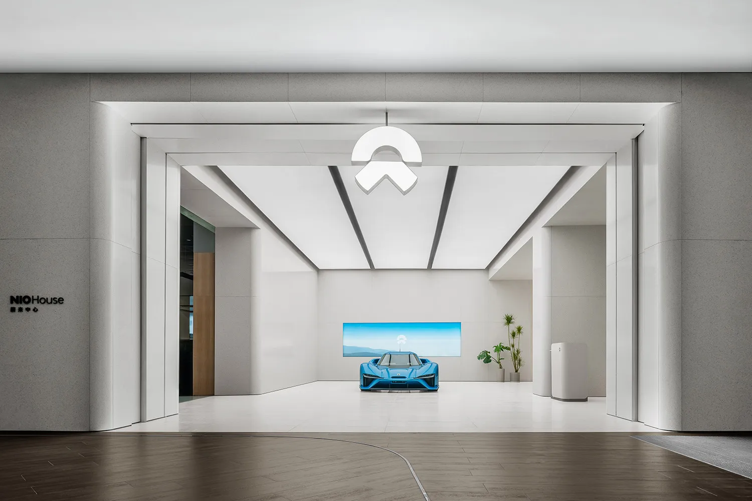 時尚現代的展示廳，藍色電動車陳列於螢幕上，並搭配簡約設計元素。