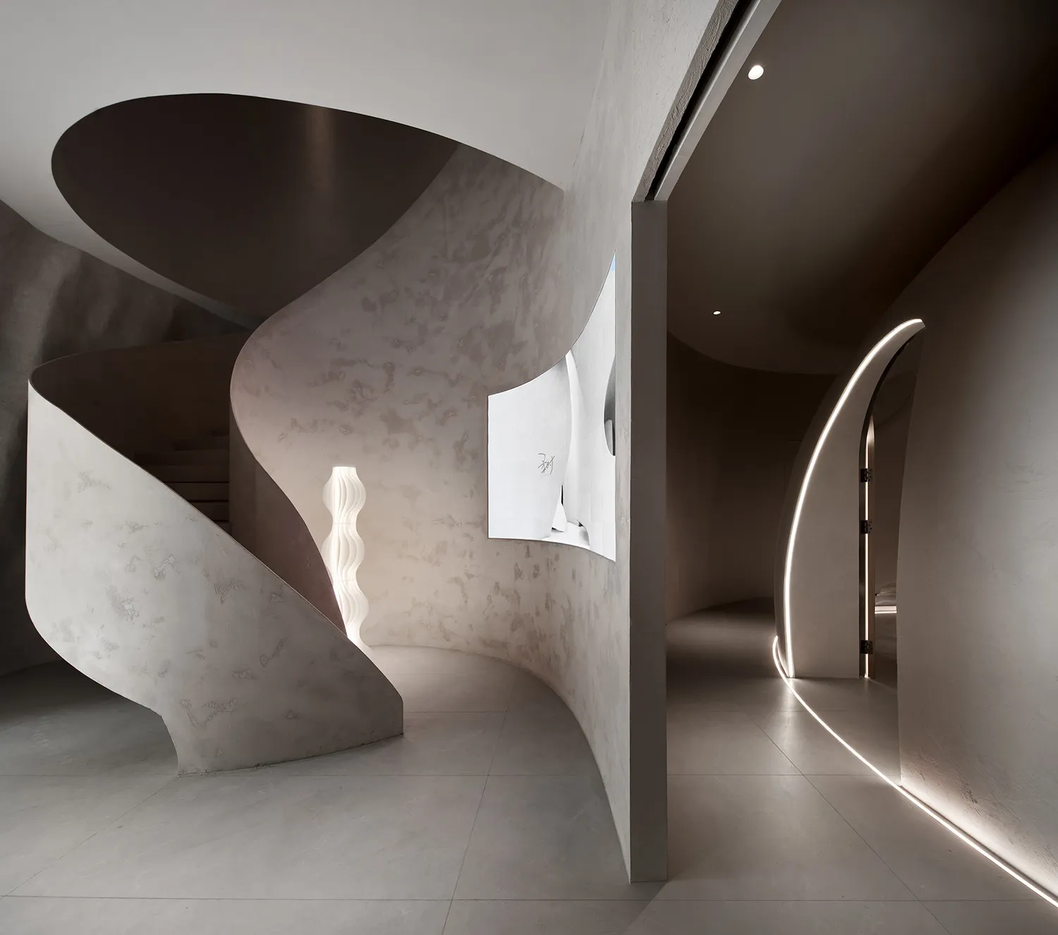 A modern interior design featuring a concrete staircase with curved surfaces and minimalist lighting in a contemporary space.