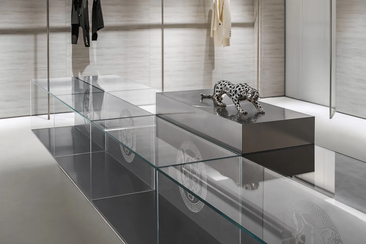 Modern retail display featuring a metal sculpture of a leopard on a high platform.
