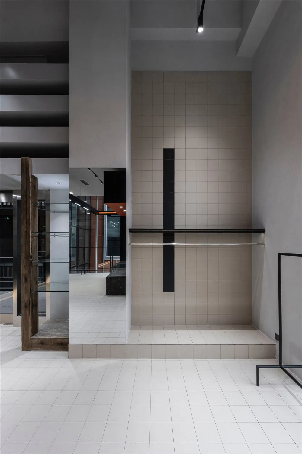 A minimalist modern industrial interior space featuring concrete walls and floors with dark metal accents.