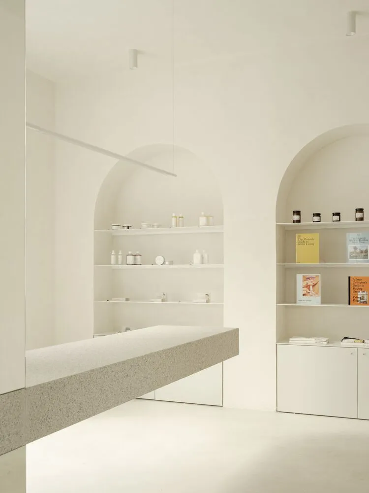 Minimalist retail storefront with concrete shelving and white products