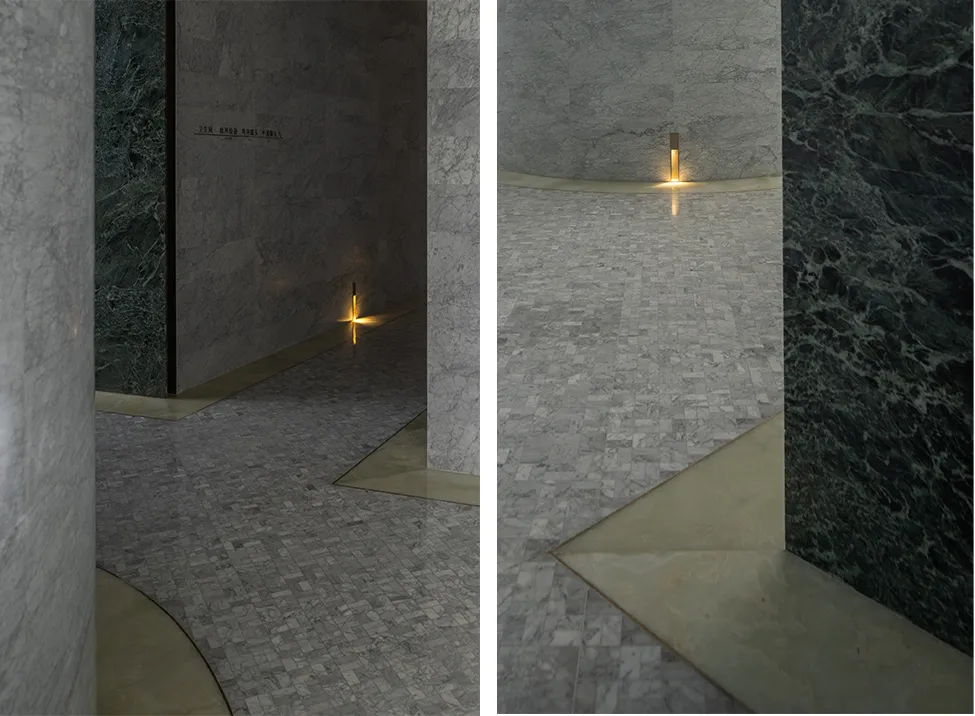 A minimalist interior design featuring marble floors and walls.