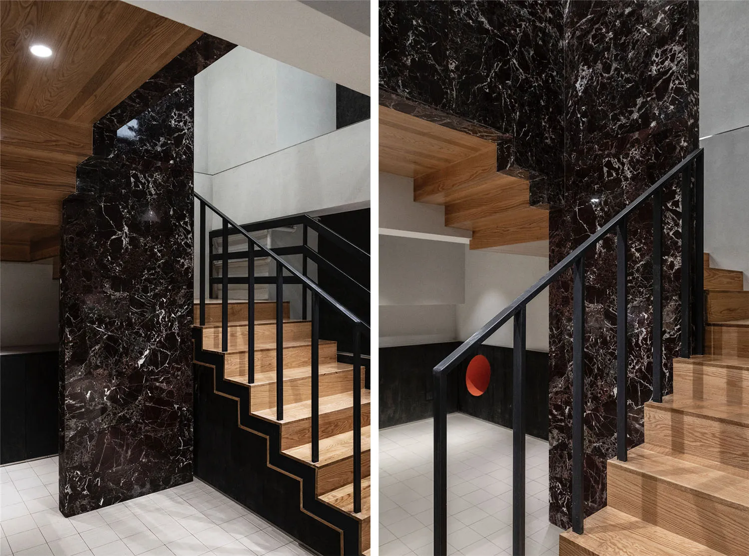 Modern staircase featuring marble walls and steel railings.