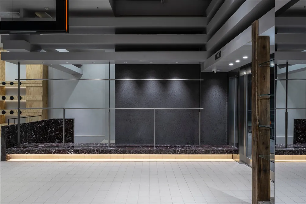 A modern interior space featuring a black marble wall and floor.
