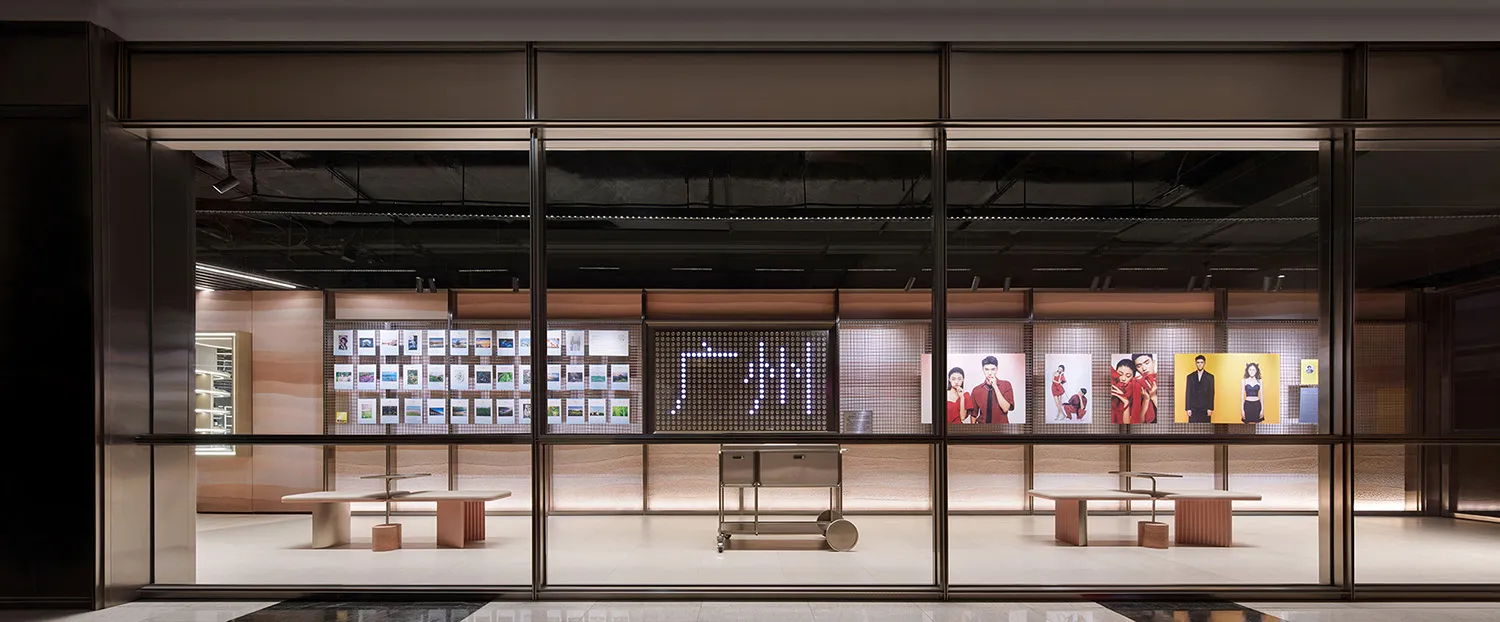 A modern retail storefront featuring advertisements on a large digital board.
