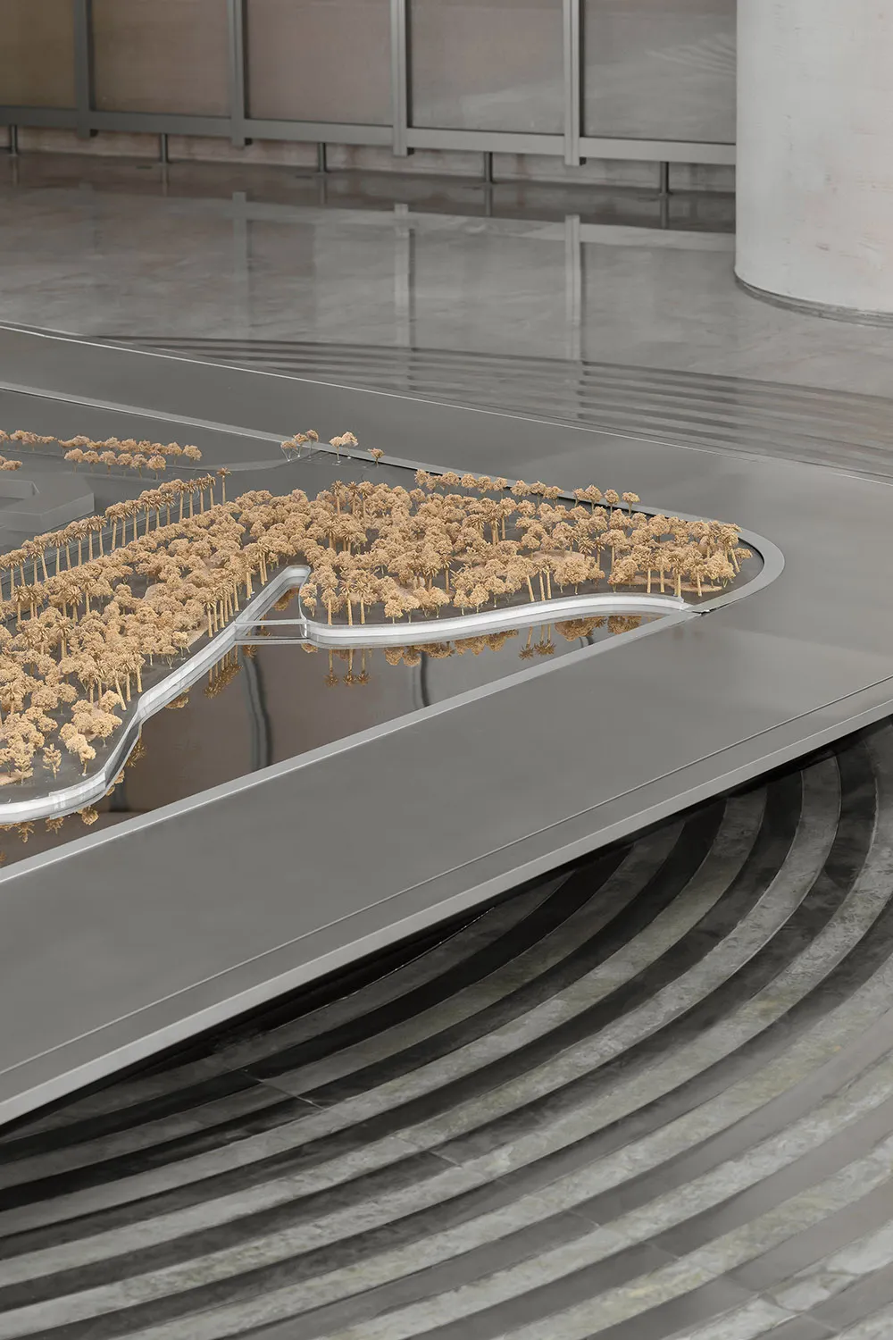 Detailed architectural model with miniature trees and curved surfaces in a contemporary setting.