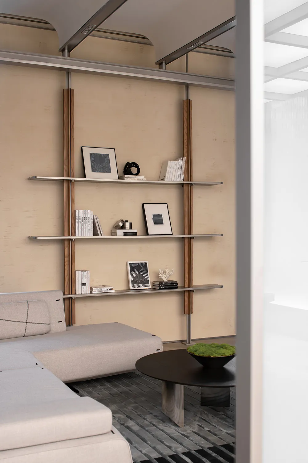 Modern living room featuring metal shelves, minimalist decor, and a sleek beige sofa