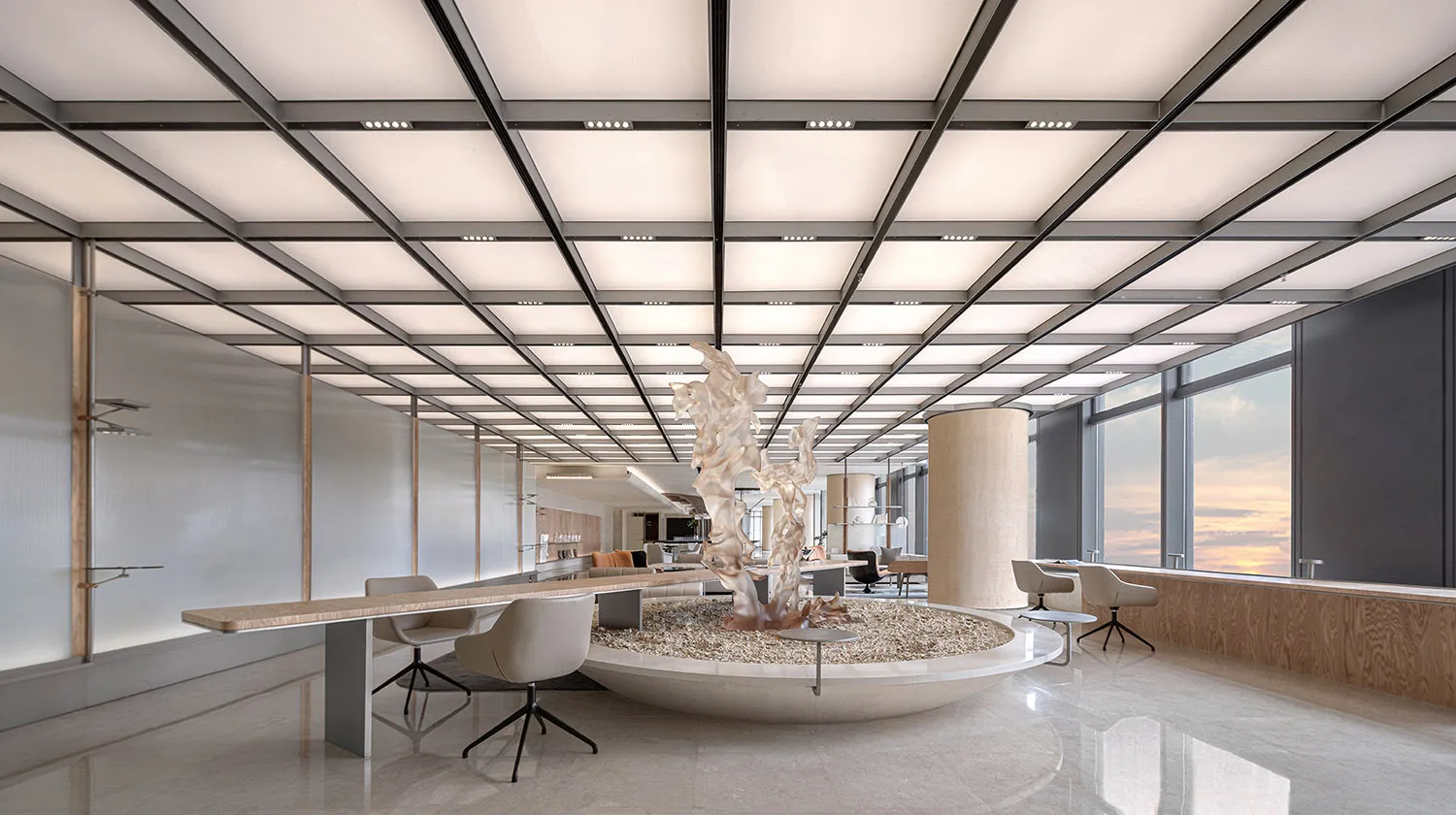 A modern office space featuring a marble sculpture, glass tables, and sleek metal accents.