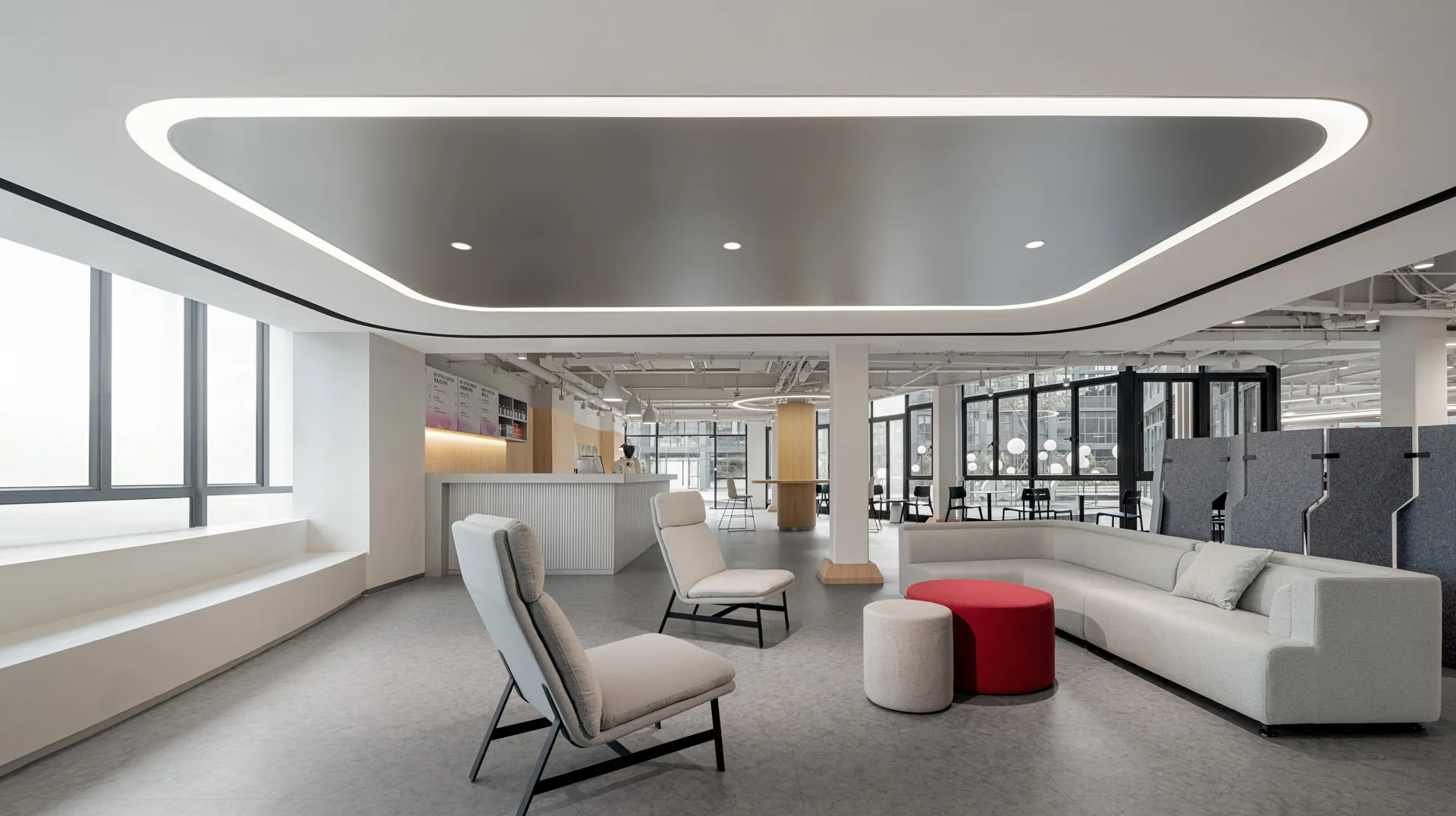 Modern office space featuring neutral-colored furnishings and seating arrangements.
