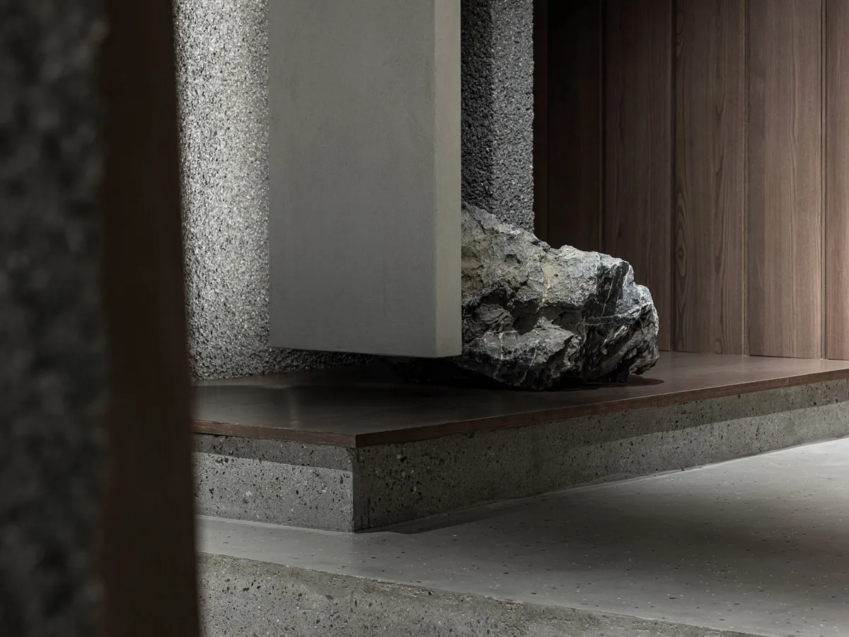A modern industrial interior design featuring concrete and rock elements on the ground