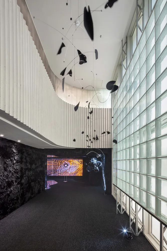 A modern interior space with a black and white metal sculpture hanging from the ceiling.