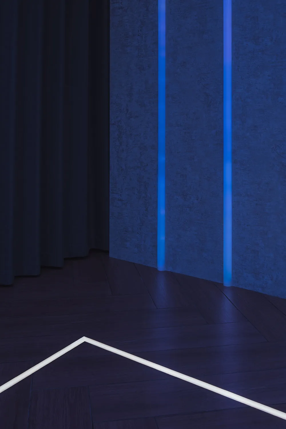 一個極簡的工業風空間,地板上有 LED 燈光線條,牆面則有垂直面板。