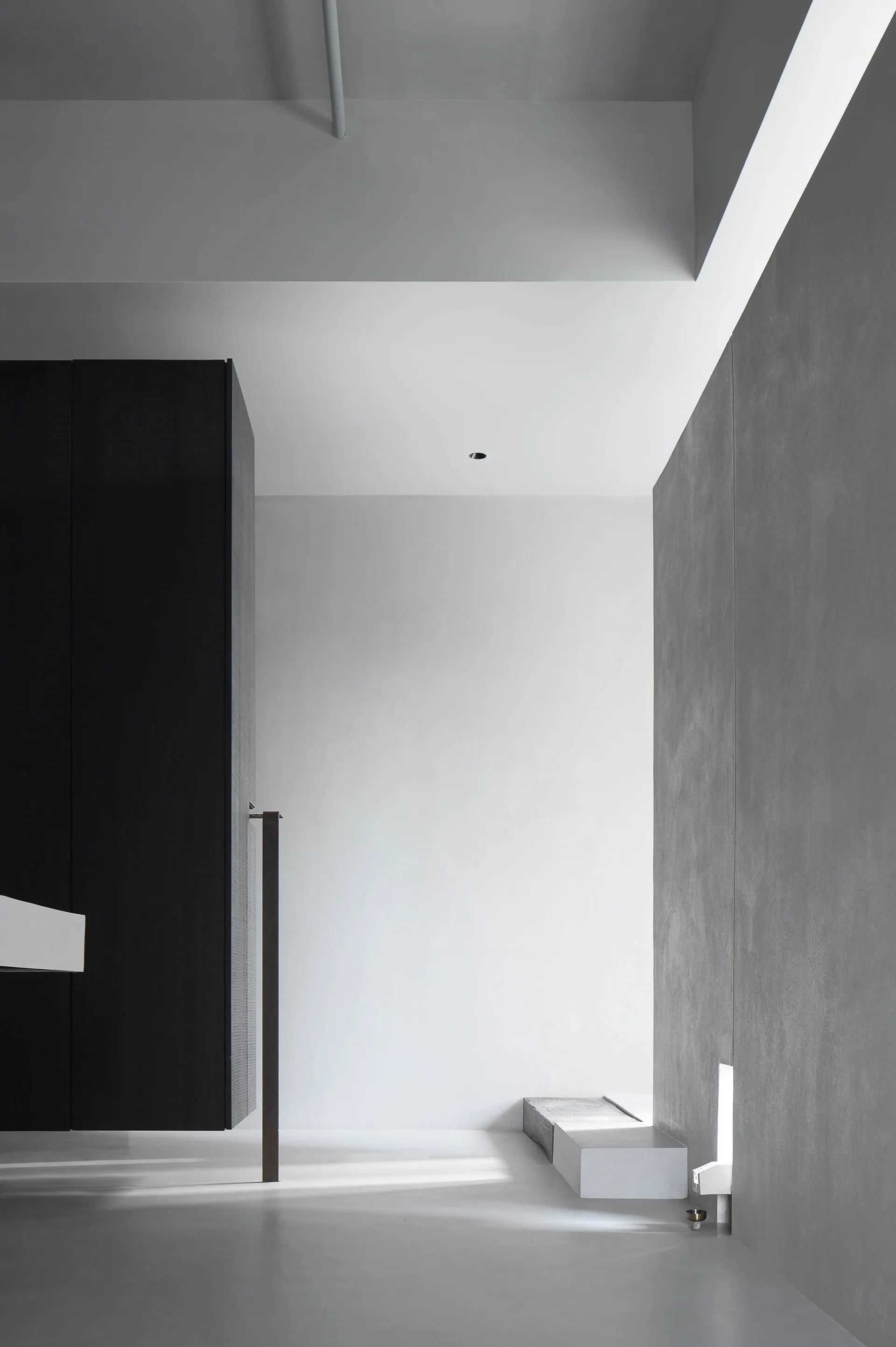 Minimalist white interior space with concrete walls and floor.