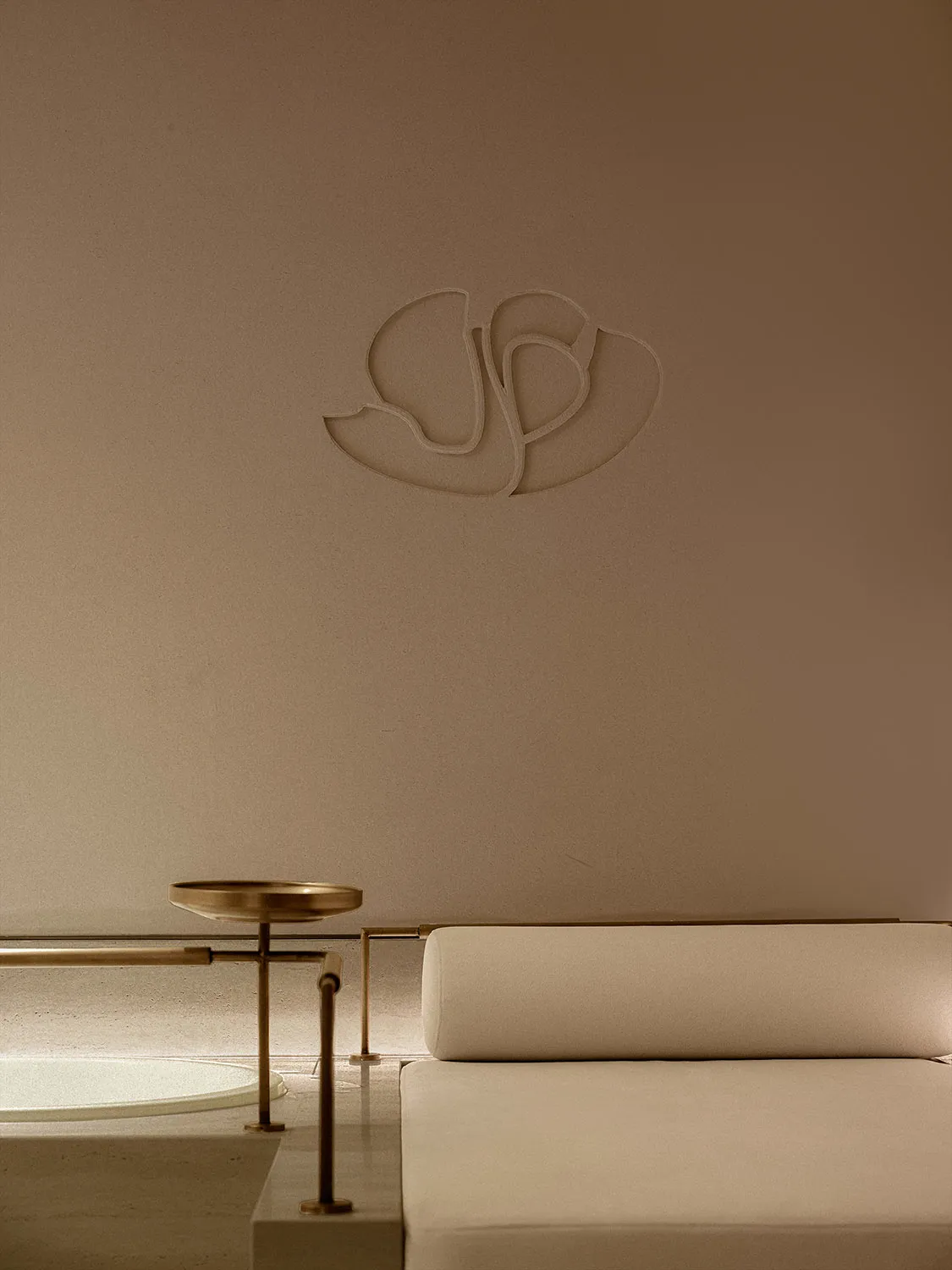 Modern minimalist interior design featuring a metal accent and beige upholstery.