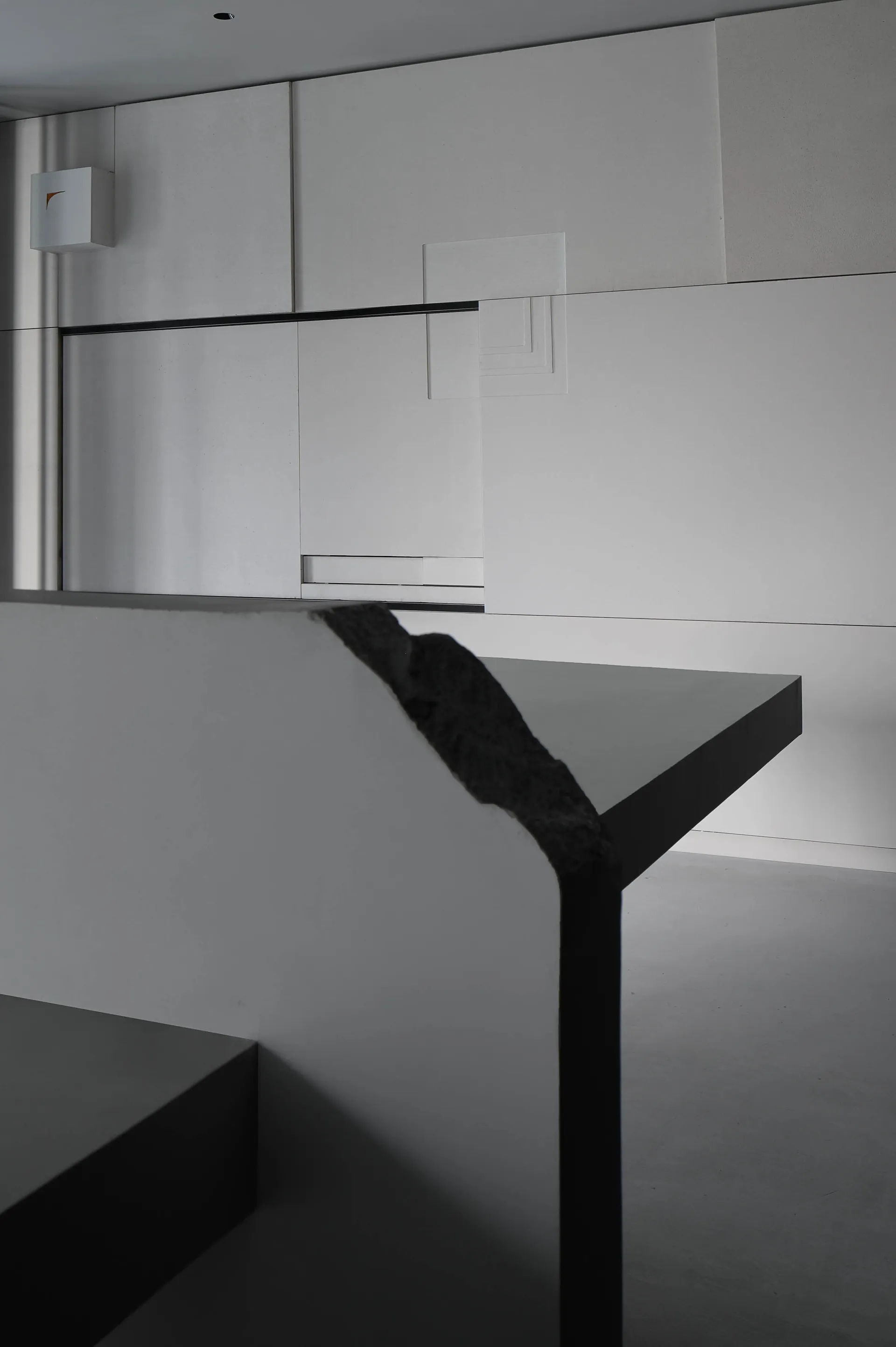 A minimalist bedroom with a concrete floor and walls, featuring a sleek design and modern style.