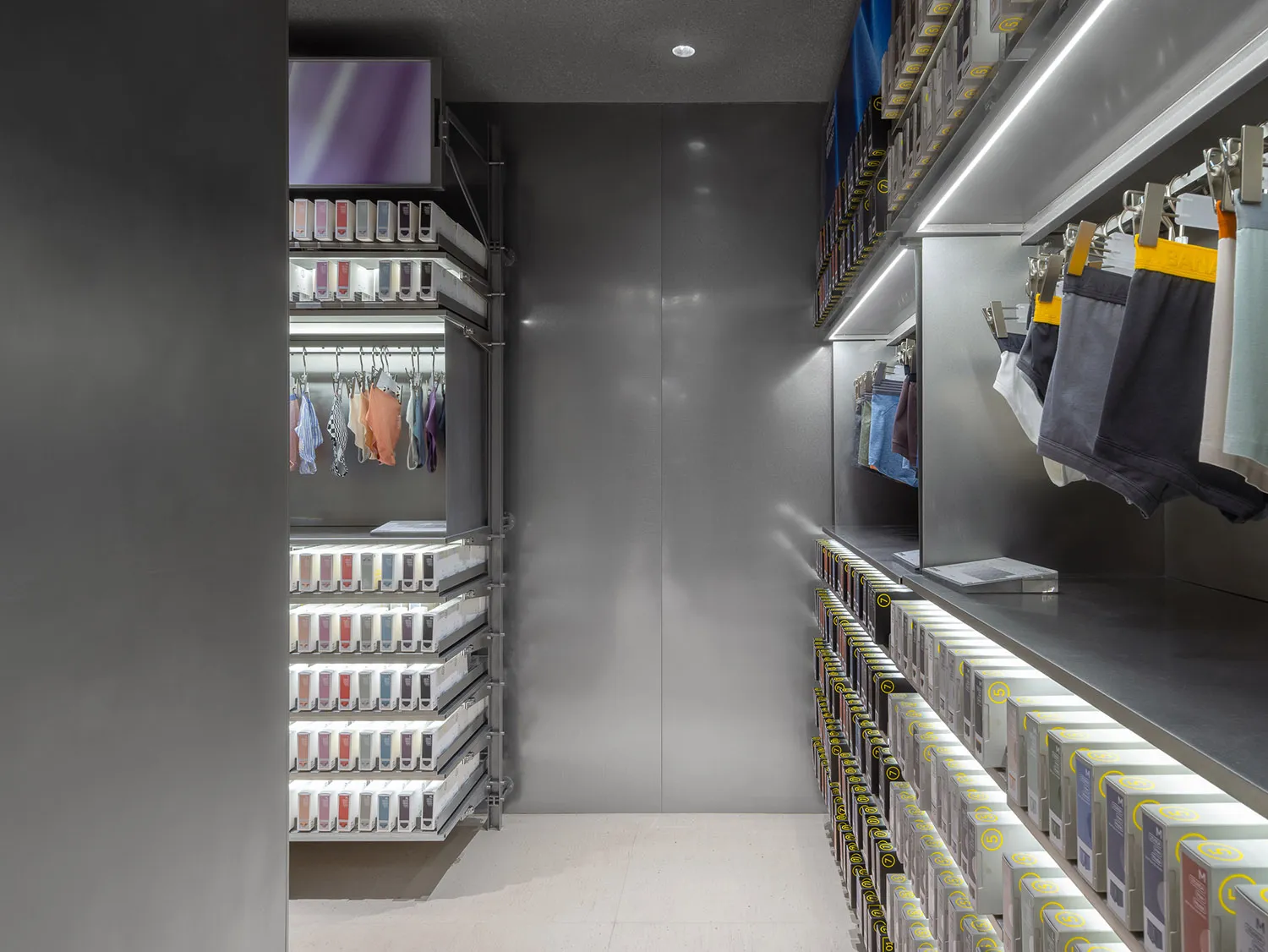 A modern retail store featuring a clothing wardrobe with metal shelving systems.