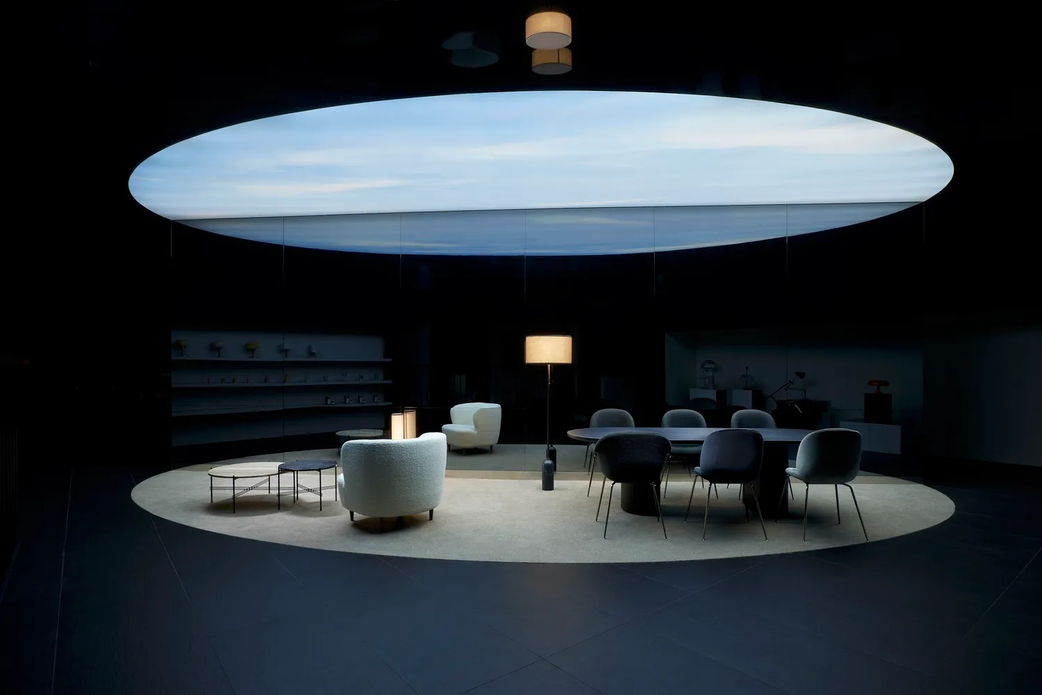A modern industrial-style office space featuring a metal desk, glass walls, and minimalist design elements.