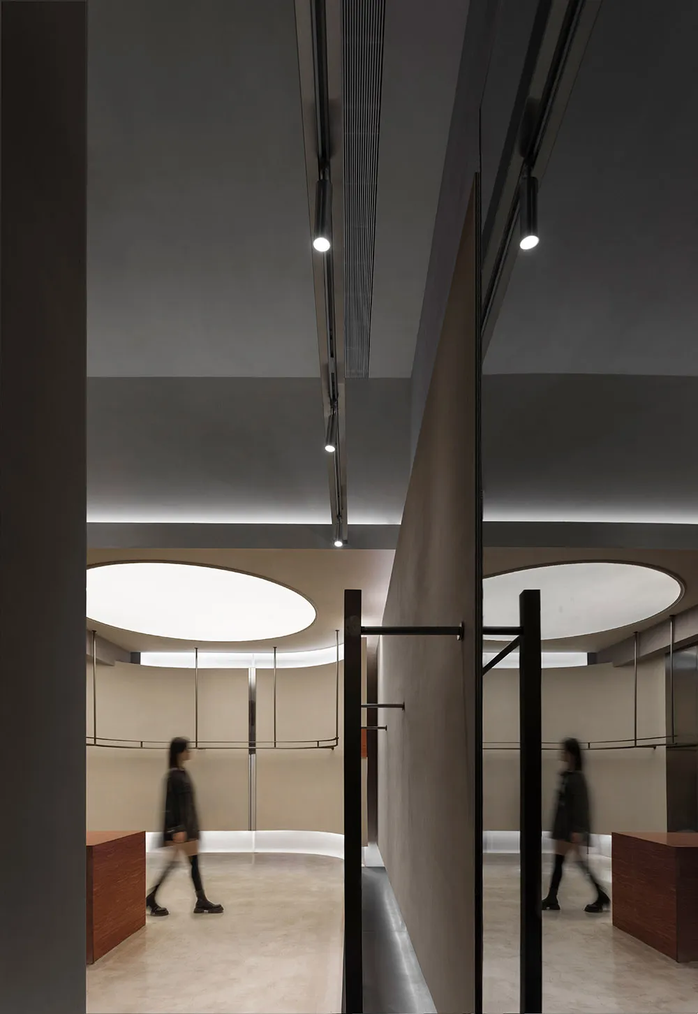 A minimalist shopping center with metallic finishes and circular light fixtures.