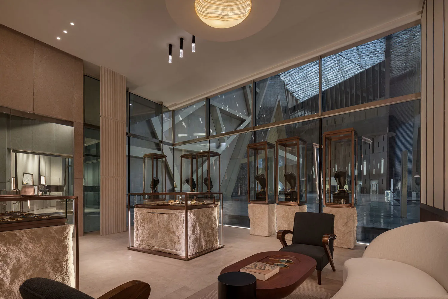 Exhibition hall in a modern art museum with glass walls and stone display cases.