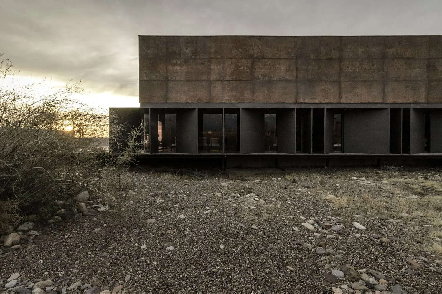 Modern building exterior made of concrete in a desert setting.