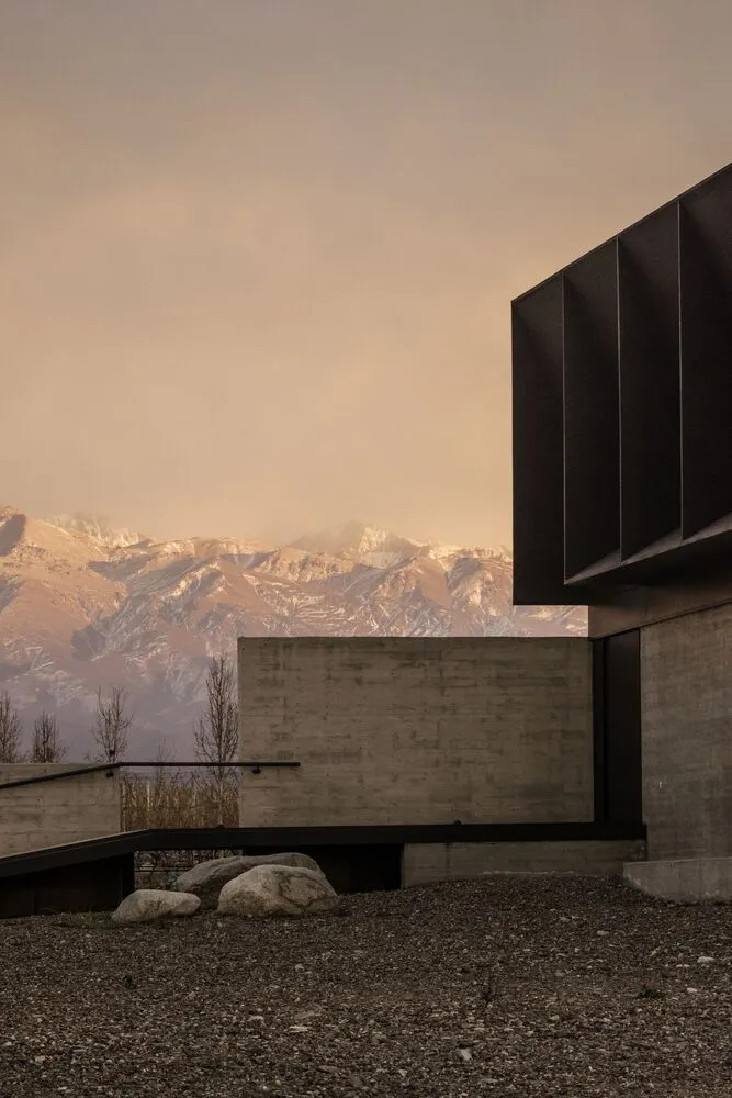 一座以混凝土建造的現代建築，背景為山巒。